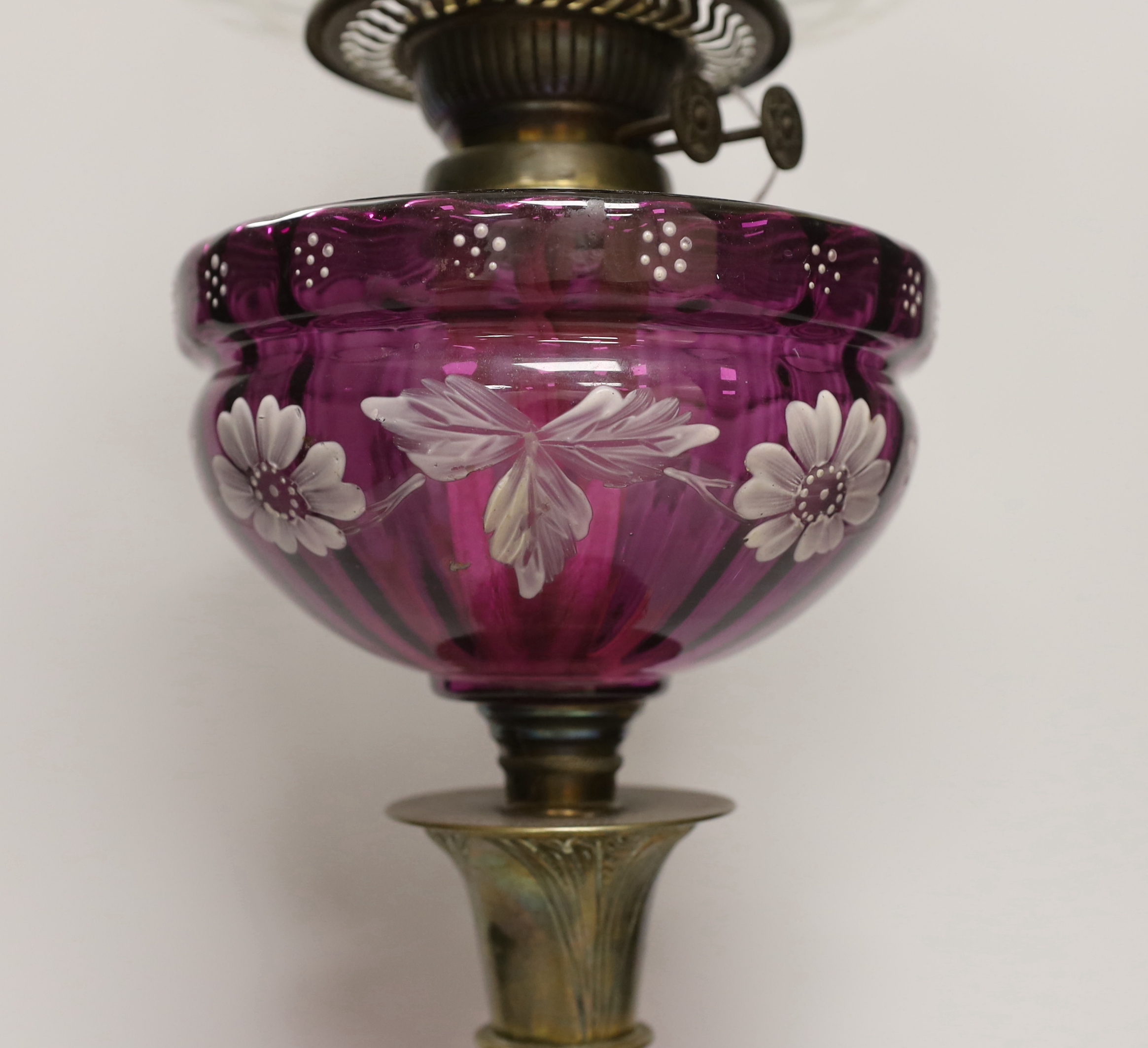 A Victorian oil lamp with an amethyst floral enamelled glass bowl and clear etched shade, 65cm high